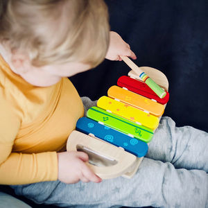 toddler playing wooden xylophone